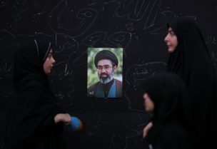 نساء يقفن أمام صورة المرشد الأعلى الإيراني مجتبى خامنئي
