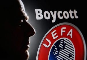 تظهر صورة ظلية لرئيس الاتحاد الدولي لكرة القدم (FIFA) جياني إنفانتينو بجانب شعار الاتحاد الأوروبي لكرة القدم (UEFA) ونص مكتوب عليه «مقاطعة». رويترز
