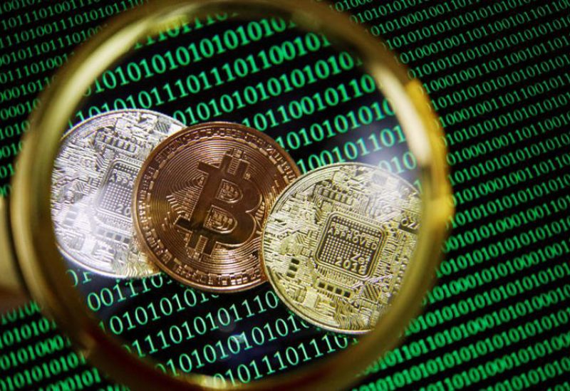 بيتكوين وعملات مشفرة أخرى ترى من خلال عدسة مكبرة في صورة توضيحية من أرشيف رويترز.