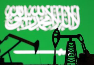 ]مجسم لرافعتي مضختي نفط بينما يظهر في الخلفية علم السعودية