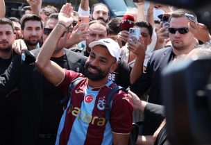 محمد صلاح يلوح للجماهير عند وصوله إلى تركيا للتوقيع مع نادي طرابزون سبور (رويترز)