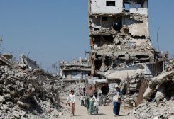 فلسطينيون يمرون بجانب أنقاض مبانٍ سكنية دمرت خلال الحرب، في مخيم جباليا للاجئين شمال قطاع غزة، في 5 أغسطس 2026. رويترز