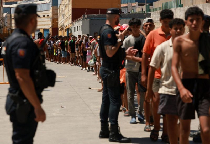 مهاجرون يصطفون لتلقي المواد الغذائية الأساسية، وذلك في ظل عمليات العبور الجماعية الأخيرة التي قام بها المهاجرون سيرًا على الأقدام وعبر البحر من المغرب إلى الأراضي الإسبانية، في سبتة، إسبانيا، في 6 أغسطس 2026. رويترز