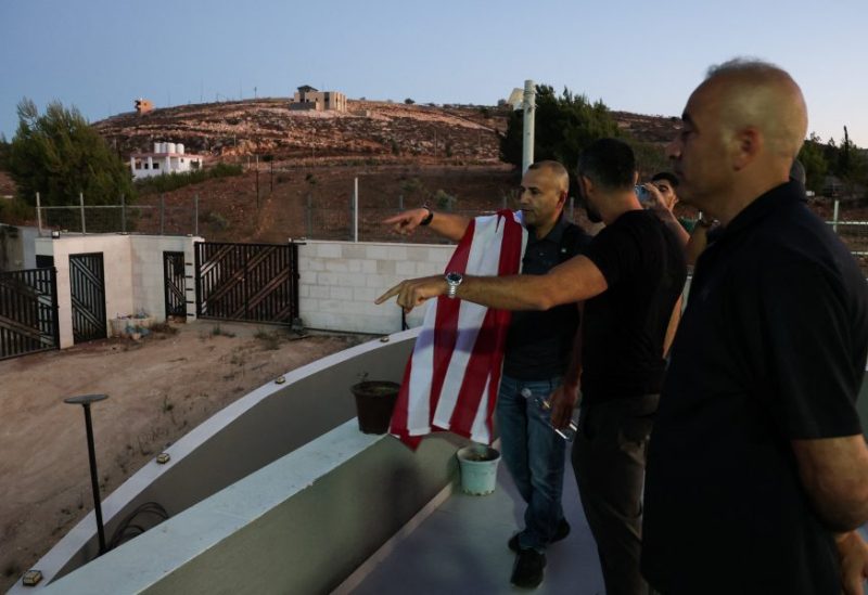 الفلسطيني الأمريكي لؤي أبو ريدة، يتحدث مع أقاربه بعد أن تمكن من الوصول إلى منزله المحاصر، في قصرة، بالضفة الغربية، في 17 أغسطس 2026. رويترز