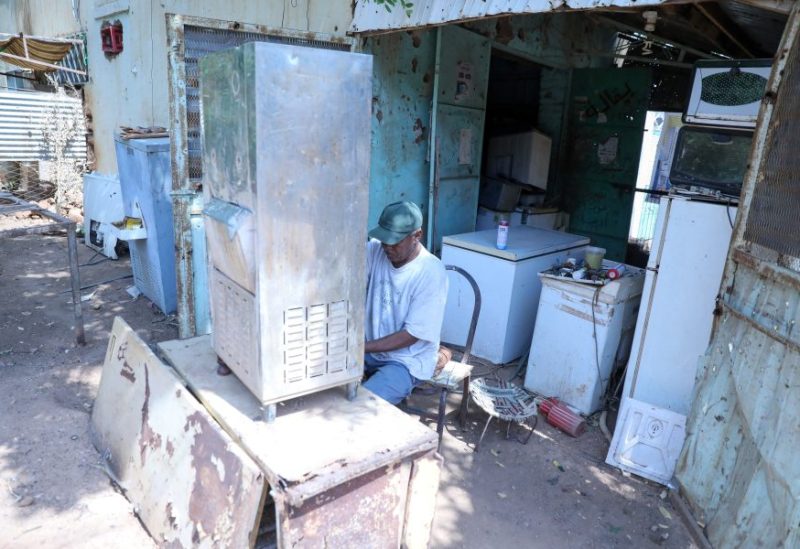 فني صيانة ثلاجات يقوم بإصلاح ثلاجة في أحد أحياء أم درمان بالسودان. رويترز