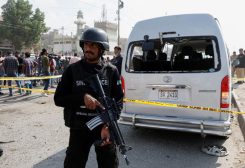 ضابط شرطة يقف للحراسةً بالقرب من مركبة تعرضت لأضرار محاطة بحواجز أمنية في موقع هجوم انتحاري في كراتشي بباكستان في صورة من أرشيف رويترز.