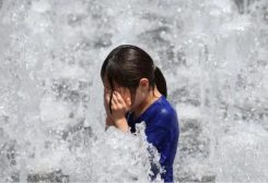 فتاة تلعب عند نافورة أرضية خلال موجة حر في وسط سيول، كوريا الجنوبية- رويترز