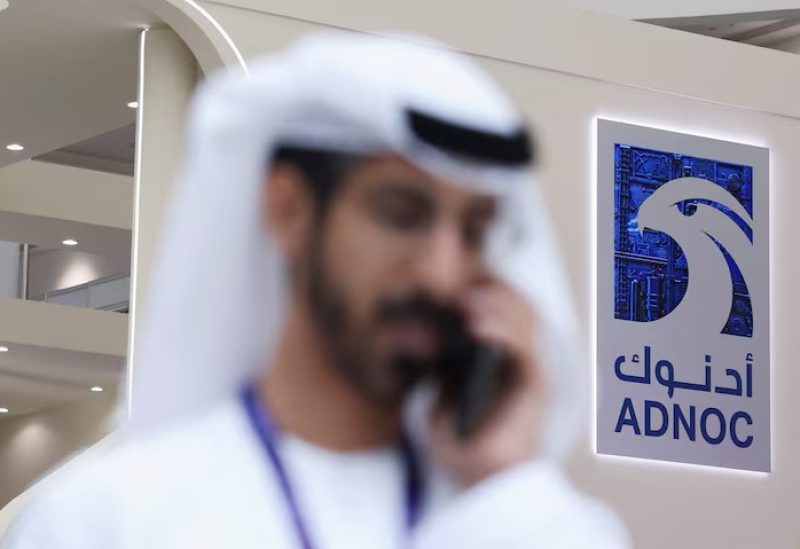 شخص يسير قرب شعار شركة بترول أبوظبي الوطنية (أدنوك) خلال مؤتمر في أبو ظبي يوم 4 مايو أيار 2026.رويترز