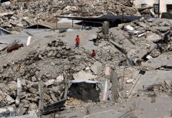 شباب فلسطينيون وسط أنقاض المباني التي دمرت خلال الغارات الإسرائيلية، في مخيم جباليا للاجئين شمال قطاع غزة. رويترز