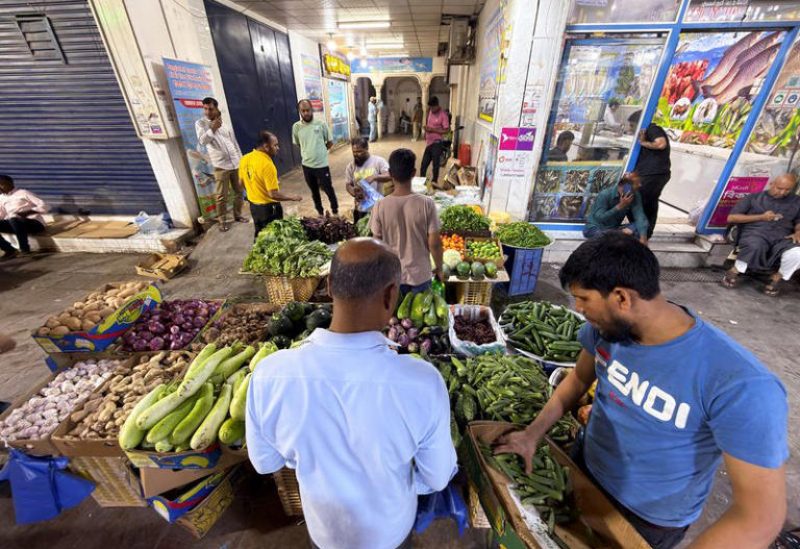 أشخاص يشترون خضراوات في سوق شعبية بالرياض. رويترز