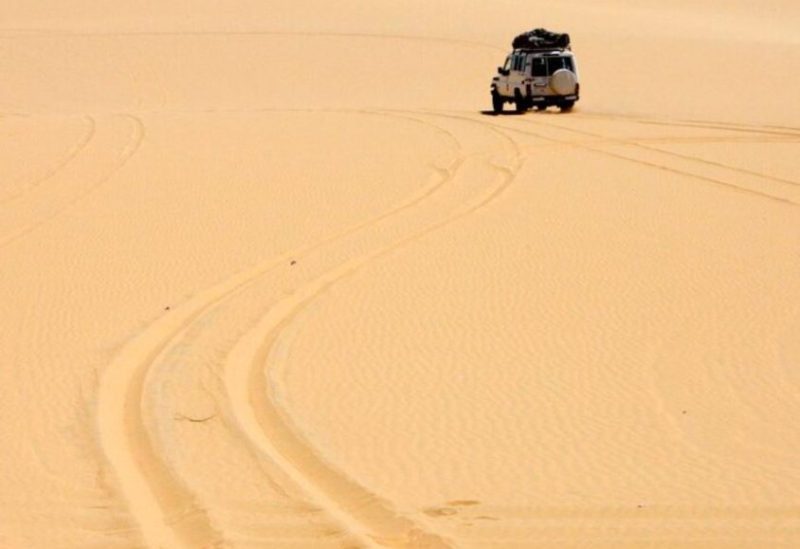 سياح أجانب يستقلون سيارة بالقرب من الواحات الداخلة في الصحراء الغربية بمصر