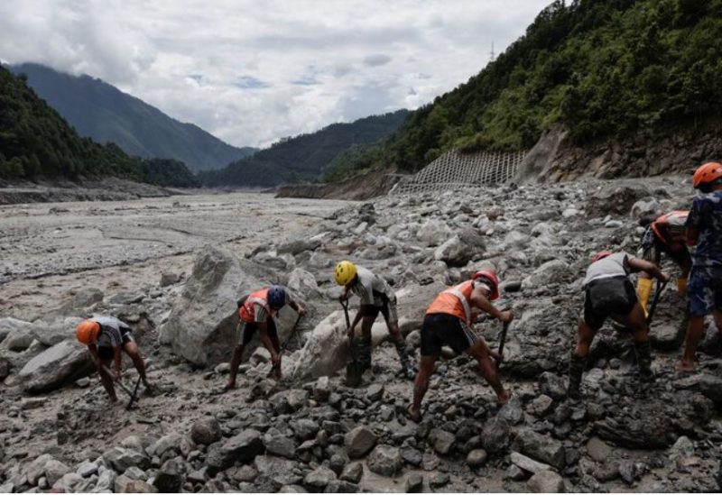 فريق إنقاذ يعمل على إزالة العوائق في موقع تضرر بسبب فيضانات مفاجئة في منطقة راسوا في نيبال
